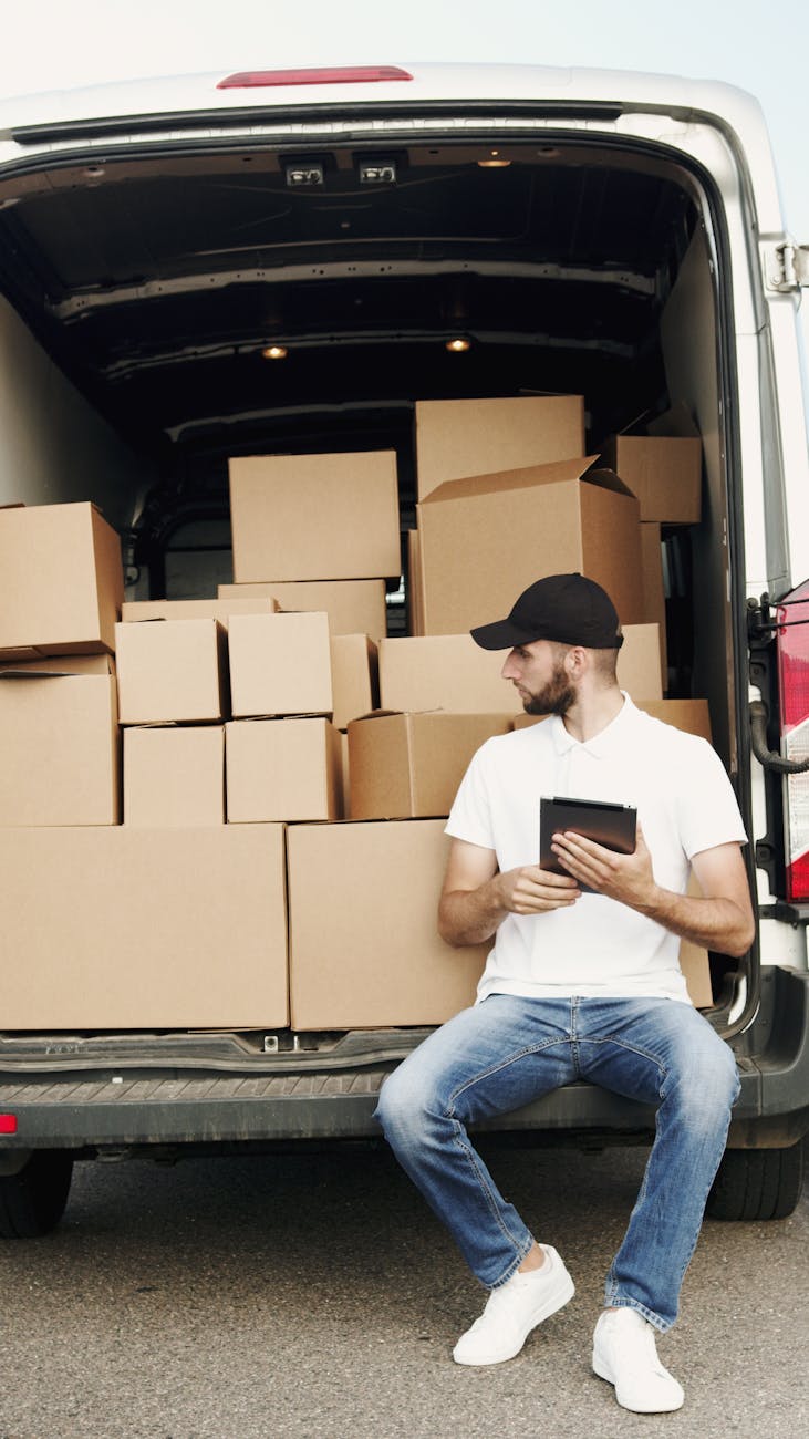 a man holding an ipad looking at the cargo boxes